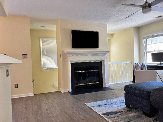 Living room view and stairwell entrance view from hallway. - 704 Rapidan River Ct Unit E