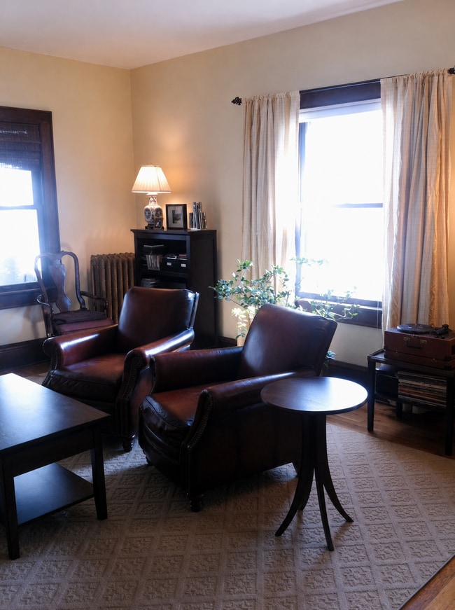 Living room with hardwood floors and large windows. - 3254 15th Ave S Unit 1S