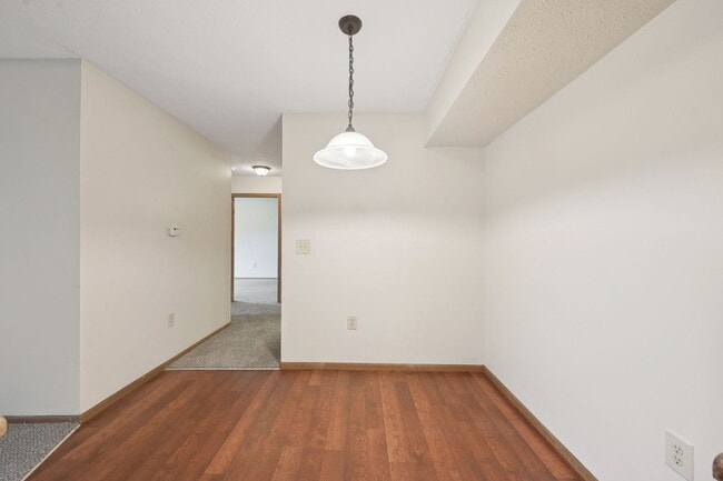Dooley's Orchard apartment unit showing a dining area off the kitchen, with a hallway leading to a bathroom and bedroom.
