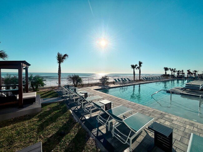 Relájese al sol junto a la piscina y disfrute de un día perfecto de ocio. - Triton Cay - Daytona Apartments