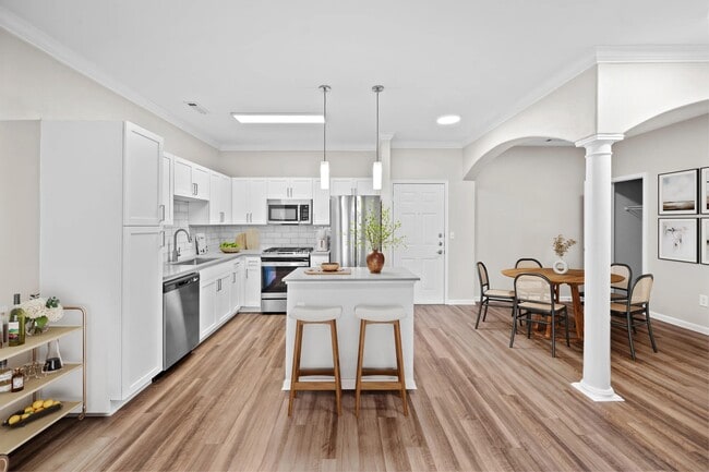 Kitchen and dining area with architectural columns, a spacious island, and an open layout that brings everyday meals and gatherings together.