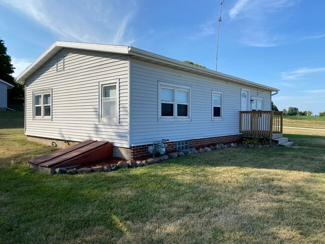 Side of house with basement access. Some shelving down there and room for storage. - W4493 Spruce Dr