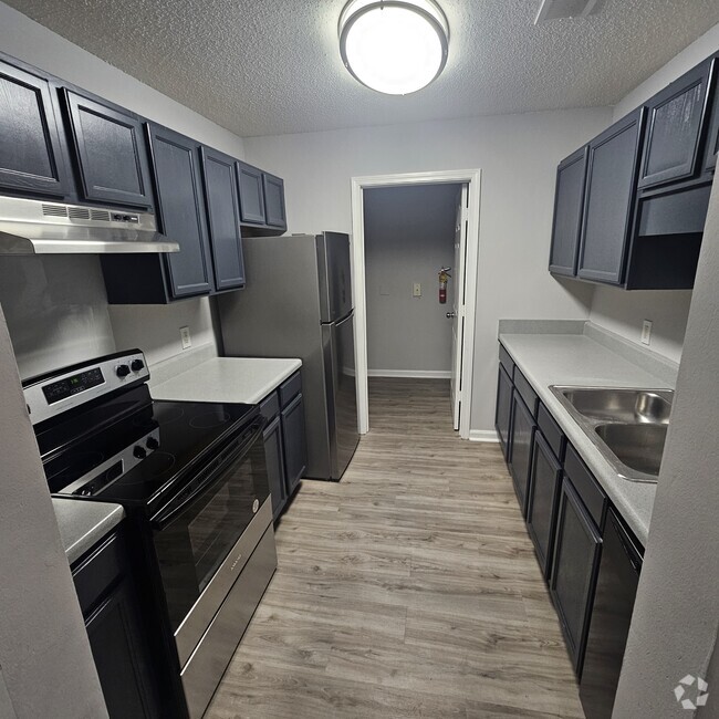 fully renovated kitchen with laundry nook - Evangeline Heights Apartments