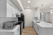Sleek kitchen design with stainless appliances and quartz counters.