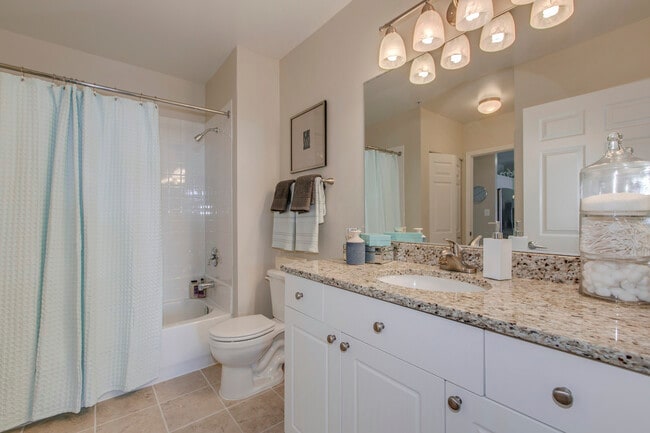 Bathroom with white cabinetry, granite countertop and tile flooring