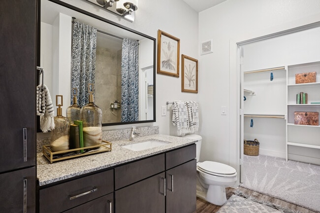 Bath with espresso cabinetry, speckled granite countertops, and hard surface flooring