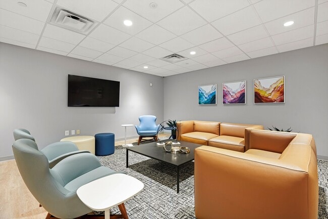Modern resident lounge with cozy seating, vibrant abstract art, and sleek furniture, offering a chic and welcoming atmosphere.