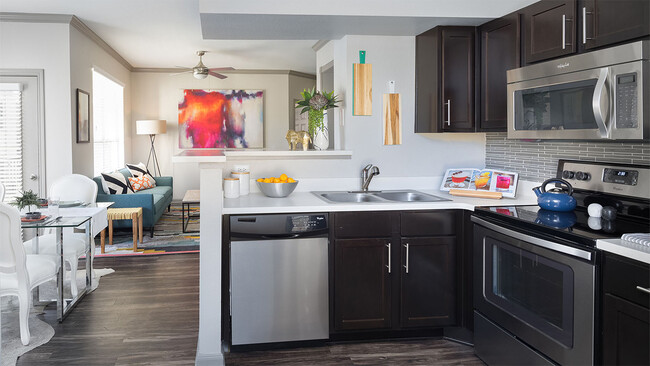 Apartment Kitchen with Stainless Steel Appliances, Dining and Living Room with wood floors. - Griffis SoCo Austin Apartments