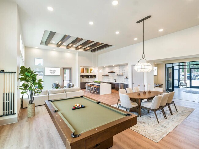 Expansive clubroom with gathering space, lounge seating, and billiards. - Beckett West Fork Apartments