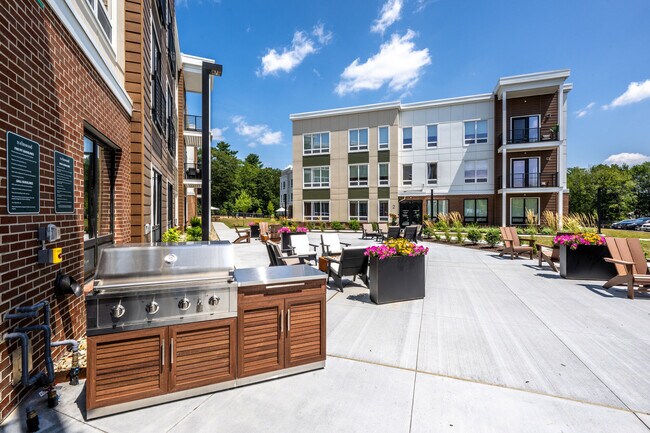 Outdoor grilling stations and gathering spaces at The Elmwood Apartments.