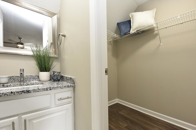 Bright bathroom with granite counters and generous walk-in closet space