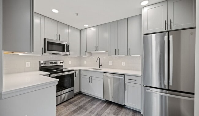 Select homes feature upgraded kitchens with quartz countertops and wood flooring - The Residences at Capital Crescent Trail Apartments