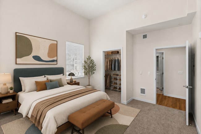 Staged bedroom showcasing the space and walk-in closet in the 841-square-foot one-bedroom Luxury floor plan.