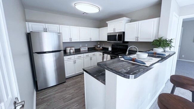 Upgrade your cooking space with chic white cabinetry and black fusion countertops. - Adley @ 72nd