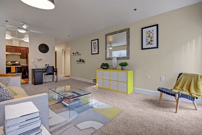 Living room with couch, desk, and view into the kitchen - Foster Greens