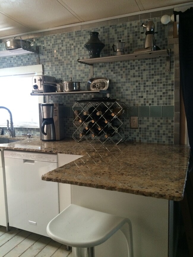 Granite counters and tile backsplash. Island seating area.