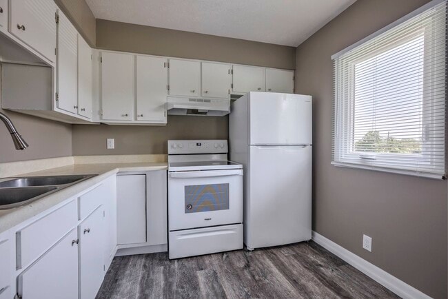 Kitchen with white appliances at Ashland Park Apartments.