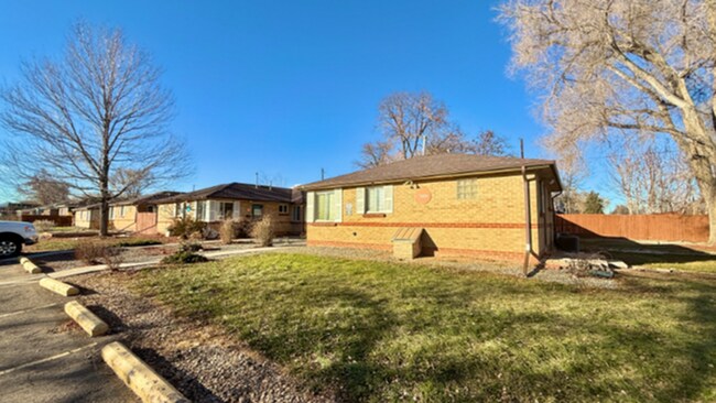 Encantadora casa estilo rancho de ladrillo con un gran patio delantero en un entorno de vecindario sereno, bañado por la luz del sol. - Flats at 16th