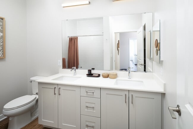 New West Phase - Finish Package III Bathroom with white quartz countertops, grey cabinetry, and hard surface flooring