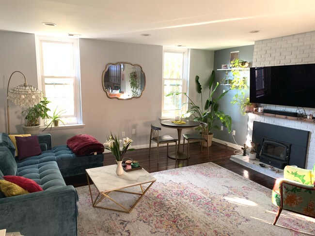 Living room with large OLED tv, lux sofa, and a corner dining area. - 1110 Lombard St Condo Unit 3