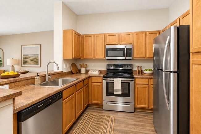 Elevate your lifestyle at Quantum Lake Villas with this modern kitchen featuring sleek stainless steel appliances and ample cabinetry. Perfect for cooking and entertaining. Explore your new home today!