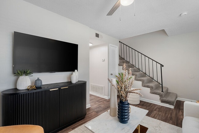 Spacious living room with hardwood-style flooring & ceiling fan