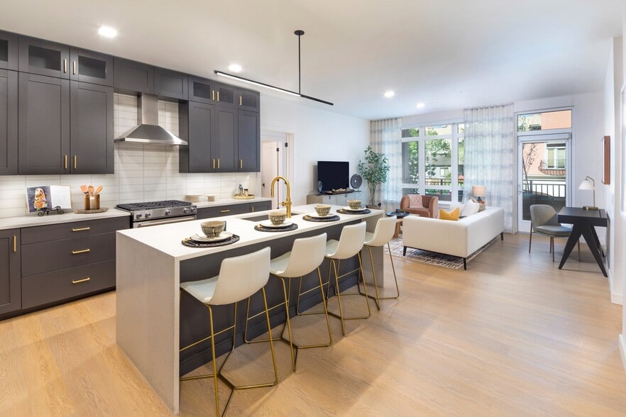 Marble-inspired quartz countertops with waterfall edge and backplash* combined with stainless steel appliances and gas ranges