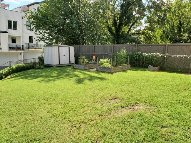 The spacious, fenced in backyard contains to raised beds - perfect for a small vegetable garden. - 1025 Wade Ave