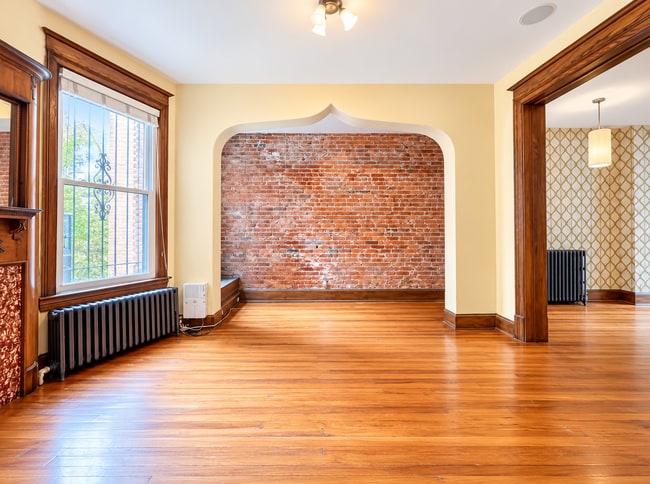 Spacious dining room featuring original hardwood floors and unique arch