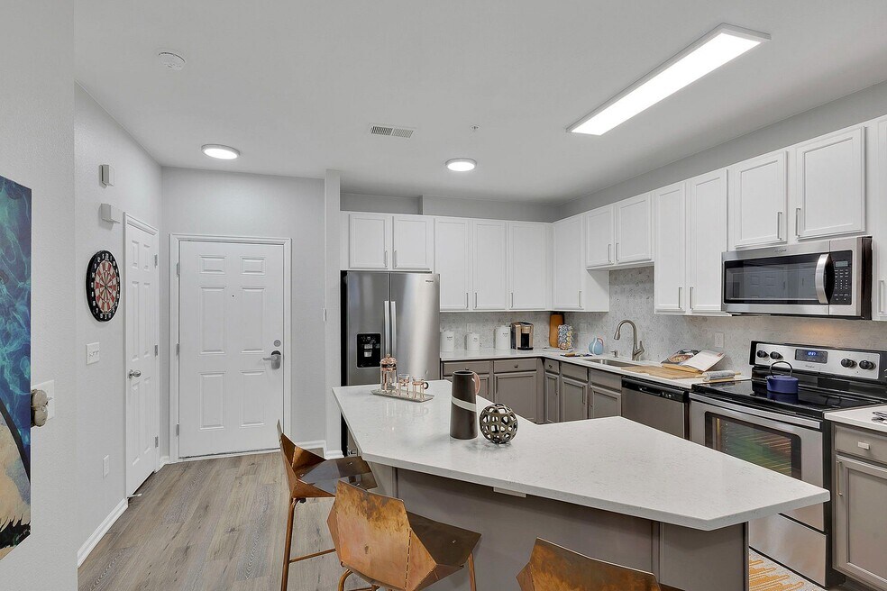 Modern kitchen with sleek stainless steel appliances, stylish white cabinetry, and elegant countertops, ideal for contemporary living.