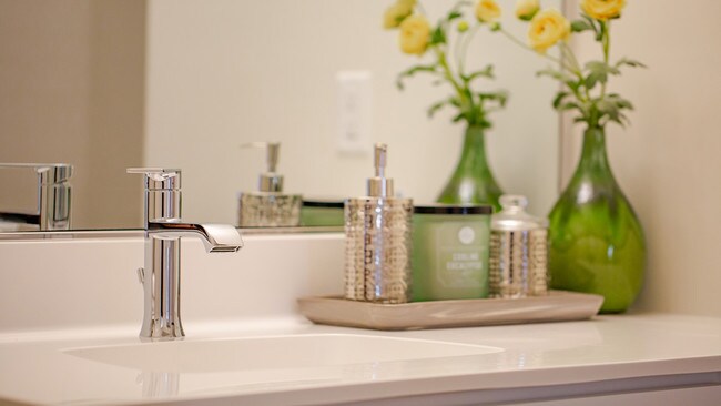Chrome fixtures and quartz countertops in the bathrooms