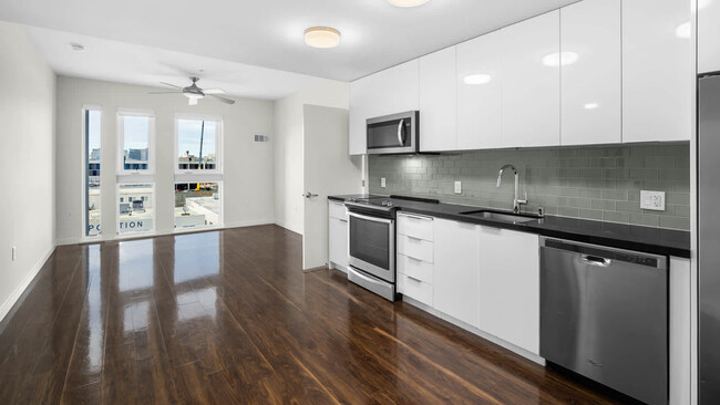 Kitchen with Stainless Steel Appliances and Living Room - Potrero 1010 Apartments