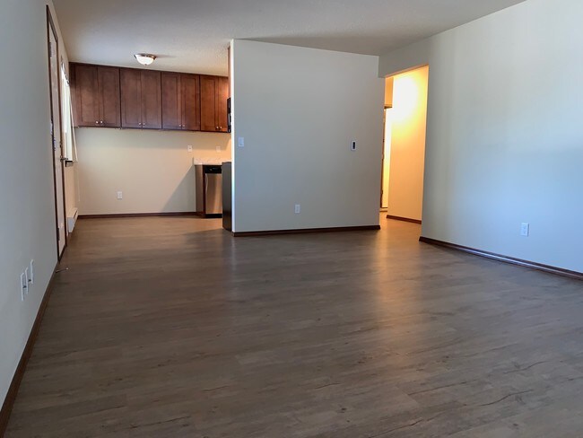 ¡Gran sala de estar con pisos de tablones! - Pearl Manor Apartments - 55+ Senior Living
