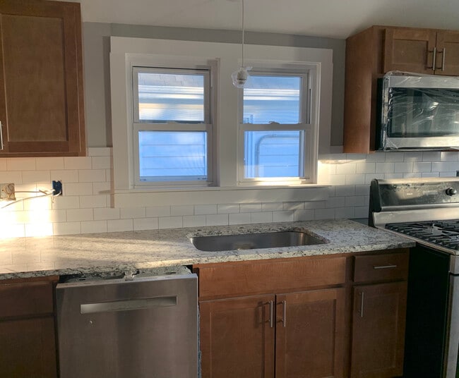 New stainless appliances, granite countertop, hand tiled backsplash. - 2163 N 62nd St Unit Upper