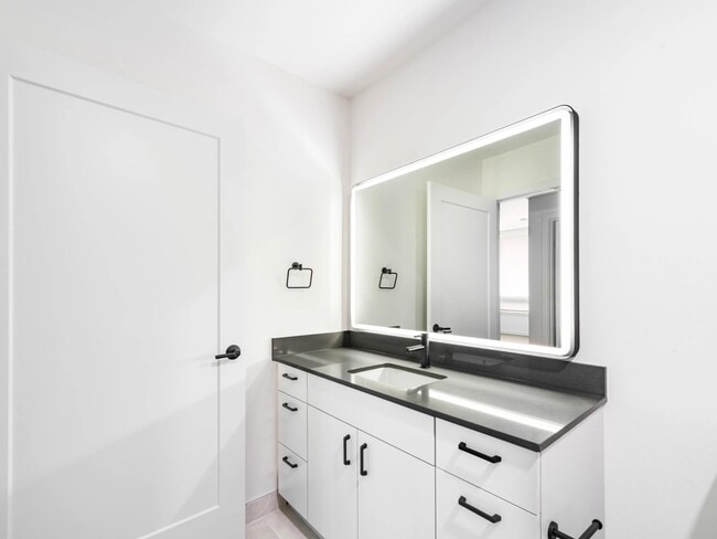 Bathroom vanity with a clean-lined sink, integrated lighting, and streamlined cabinetry creating a bright, functional space for daily routines.