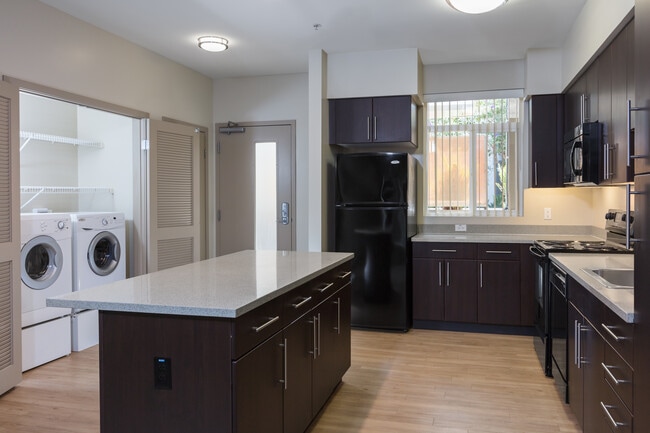 Classic Package I kitchen with black appliances, grey speckled granite countertops, espresso cabinetry, and hard surface flooring