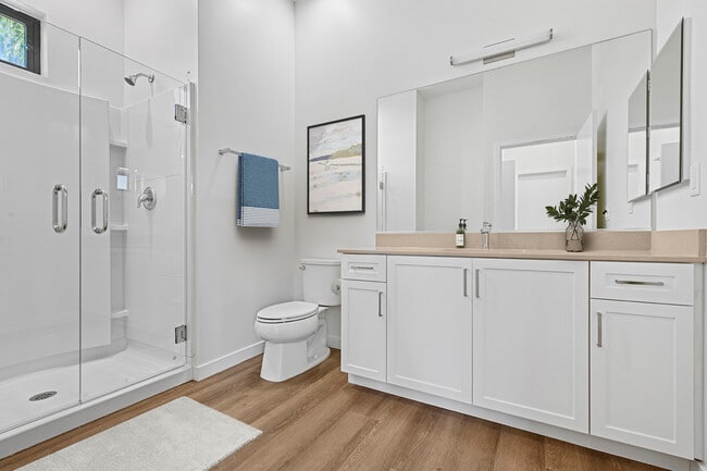 Freestanding Home bath with beige quartz countertop, white cabinetry, and hard-surface flooring