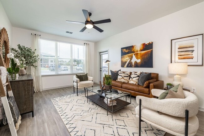 Large window and ceiling fan in apartment living rooms at The Groves at Lake Juliana - The Groves at Lake Juliana