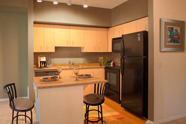 Classic Package I kitchen with black appliances, laminate countertops, oak cabinetry, and hard surface flooring