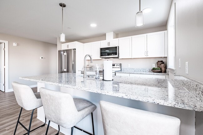 Cook, gather, and entertain with ease in a thoughtfully designed kitchen featuring a spacious granite island, modern white cabinetry, and a smart LG appliance package.