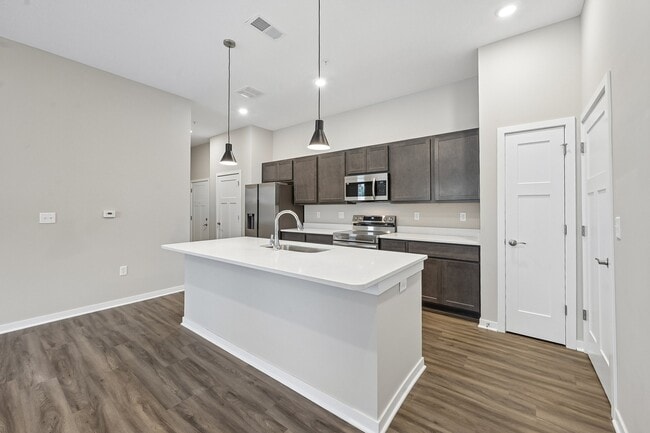 Fully equipped kitchen with microwave, stove, oven, dishwasher, and refrigerator of an available floor plan at Flats of Sugar Run luxury apartments in Delaware, OH.