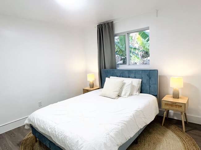1st bedroom with queen bed and banana tree views - 6863 NW 2nd Ave