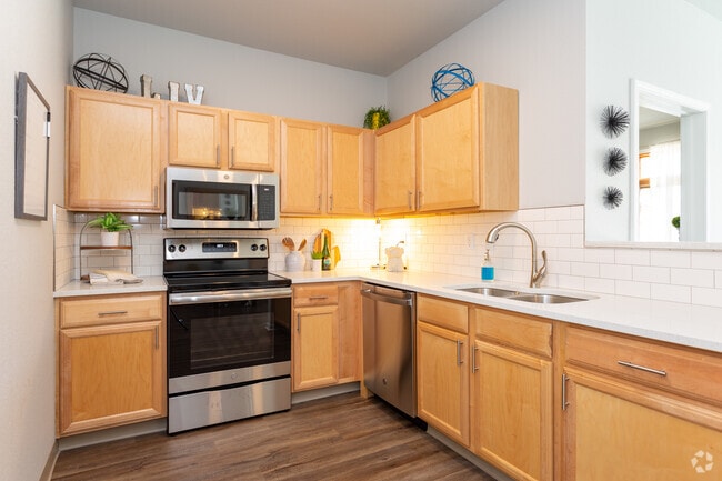 Gourmet kitchens with electric range, subway tile backsplash, and an island with breakfast bar.