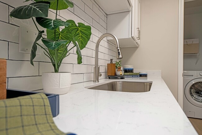 Granite counters & farmhouse kitchen sink - The Collins Apartment Homes