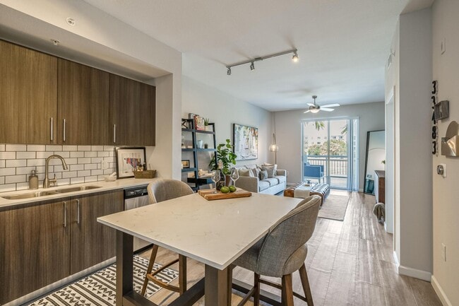 Island with Seating and Full Kitchen Facing Sofa and Sliding Doors - South of Atlantic Luxury Apartments