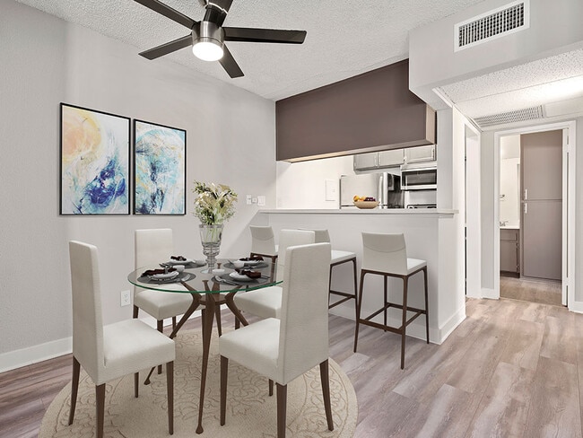 Dining room with view of ceiling fan and bar seating in kitchen.