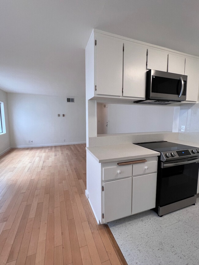 Open living and dining area with pass-through kitchen — ideal for entertaining or everyday living. - 11639 Chenault St Unit 403