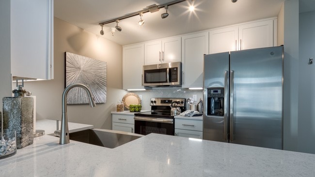 Ceiling-high cabinetry allows you to store all your kitchen wares where you need them. - The Cosmopolitan Apartments