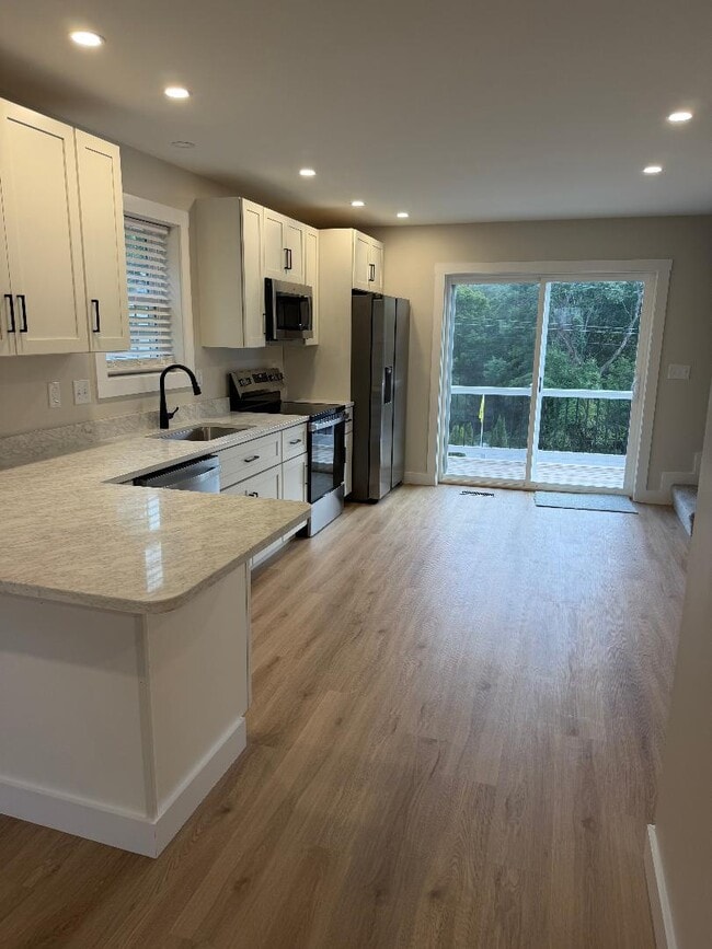 Kitchen with dishwasher and stainless appliances - 24 Munroe St Unit B