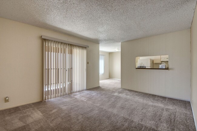 A large living room with sliding glass doors out to the patio and easy access to the kitchen - Fairgreen